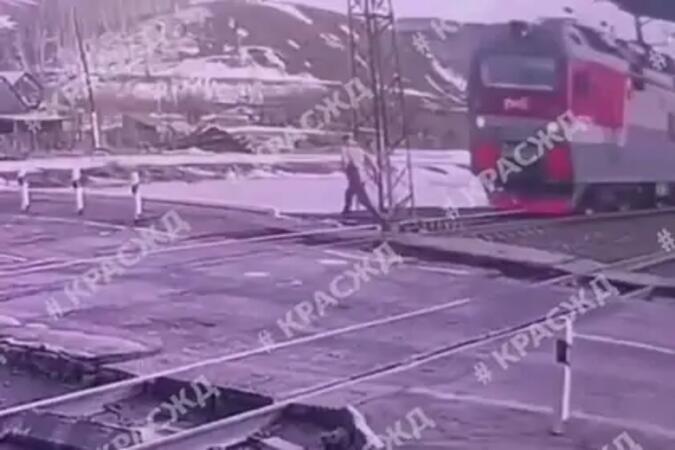 Россиянин перебежал пути в миллиметрах от несущегося поезда и попал на видео